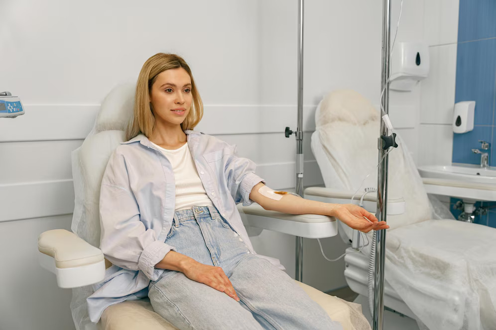 smiling-woman-patient-sitting-armchair-while-receiving-iv-infusion-treatment-hospital